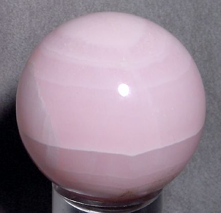 This Mangano Calcite sphere is a soft pink color with varying bands of 